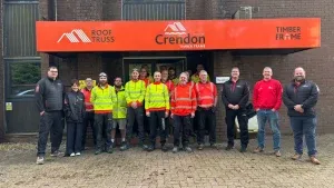 Team of workers posing for photos in front of an office entrance