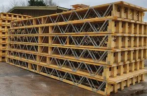 Stacks of Posi-Joists outside a warehouse on a wet day