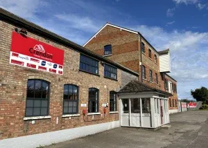 Outside a red and brown brick Crendon office building with a porch on a sunny day