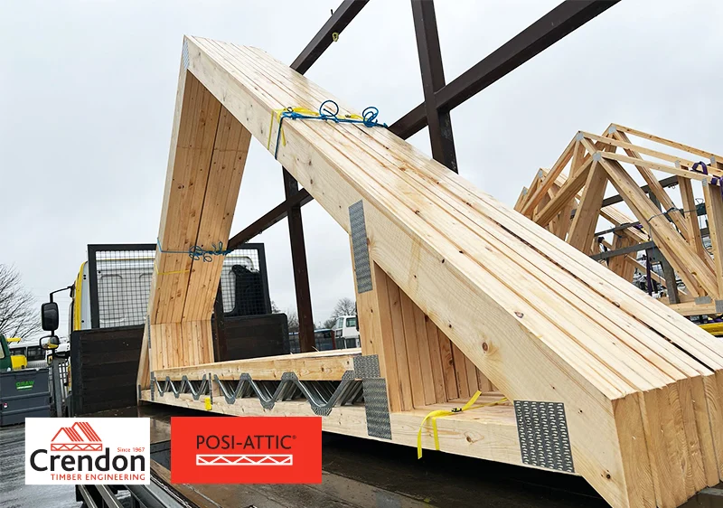 Large prefabricated timber roof truss on a Crendon flatbed lorry, with Posi-Attic and Crendon logos.